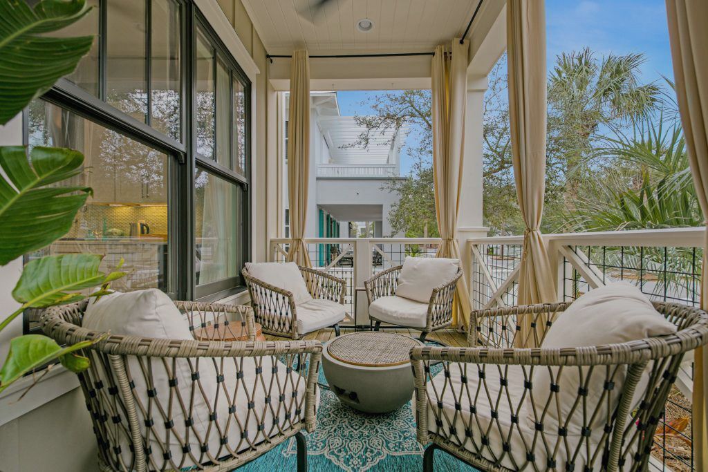 Cozy outdoor patio furniture arranged in a spacious covered porch lounge area.
